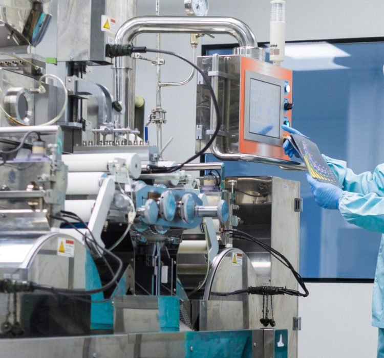 widescreen picture, caucasian scientist in blue lab suit trying to fix manufacture machine with shafts in clean factory